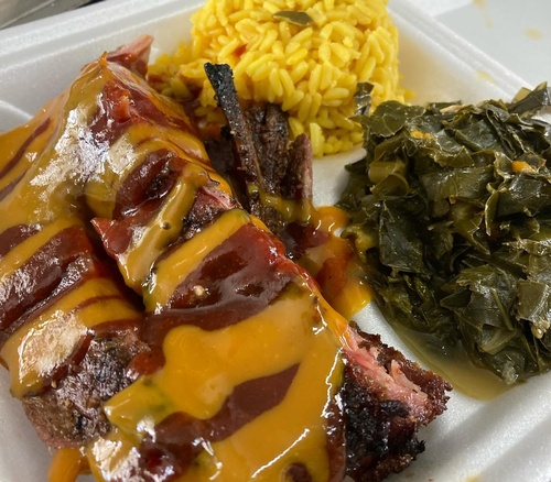 Smoked ribs with sweet and smoky drizzle, yellow rice and collard greens plate